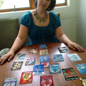Woman sitting at table with colorful cards in front of a window