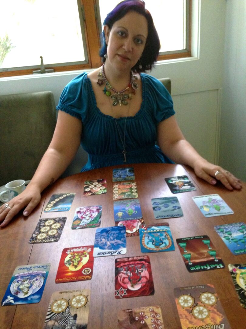Woman sitting at table with colorful cards in front of a window